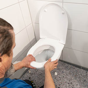 Montage eines WC-Sitzes bei der Modernisierung im Bestand.